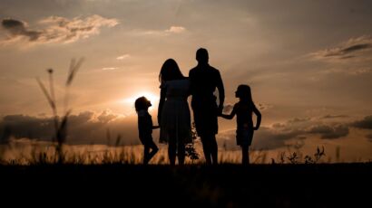 a family standing in a field at sunset
