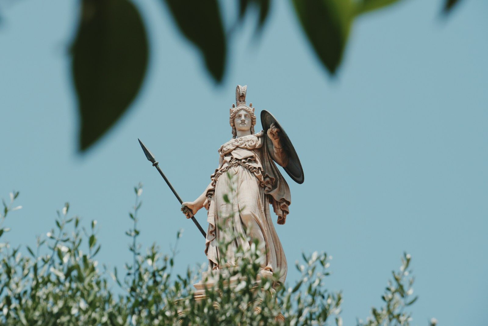 Statue of athena towers above the foliage