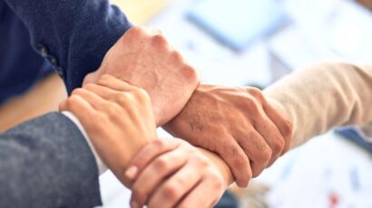 team members gripping wrists in unity gesture
